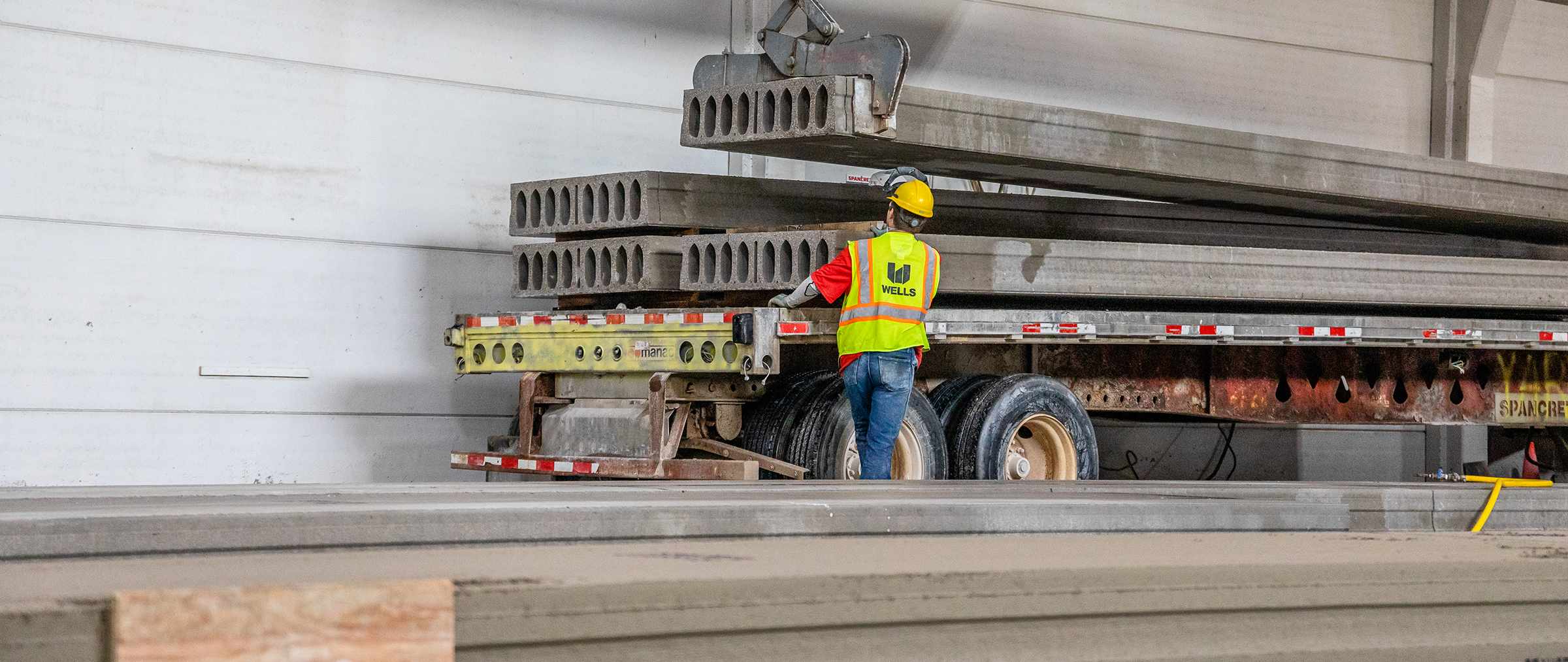 hollowcore being stacked on a flatbed truck in manufacturing facility