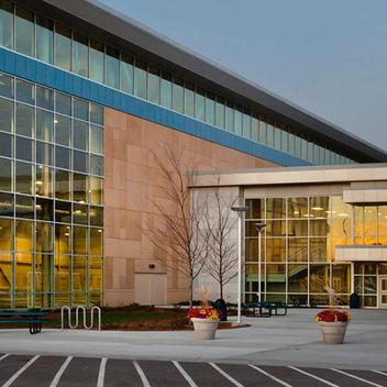 Wide view of Bielenberg Sports Center from the front, picturing the entrance at sunset