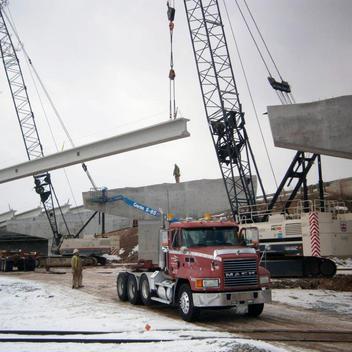bridge girders being taken off a truck