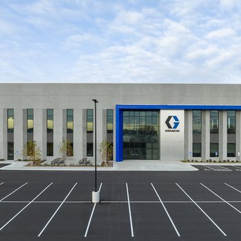 entrance of graco distribution center with sky and parking lot