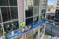 Image of maintenance workers sealing a high rise building