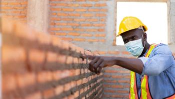 Man touching brick wall